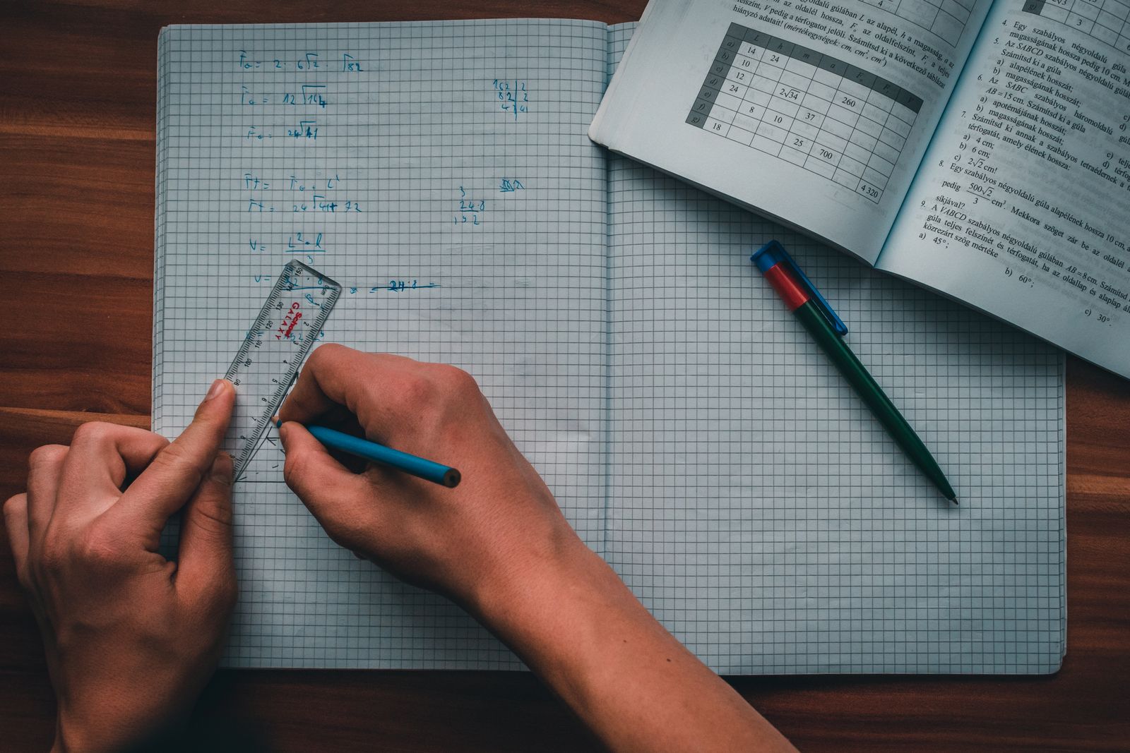 Student writing in a notebook while revising IGCSE Physics Paper 6